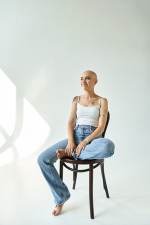A young bald woman exudes self assurance as she poses gracefully in soft light.の写真素材