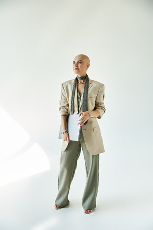 The young bald woman stands confidently in elegant attire, showcasing her unique beauty and grace.の写真素材
