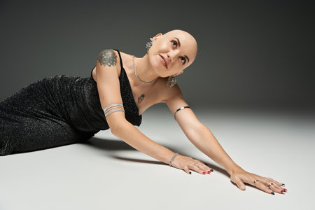 A young bald woman showcases confidence and elegance while striking a captivating pose.の写真素材