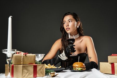 A young woman dressed elegantly savors a gourmet meal surrounded by decorations.の写真素材