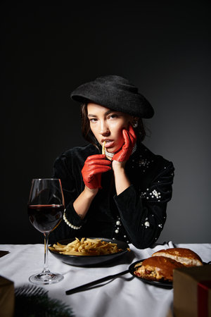 A stylish woman in elegant clothing savors her meal, exuding confidence and charm.の写真素材