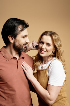 A couple enjoys a playful moment, smiling as they embrace in a cozy atmosphere.