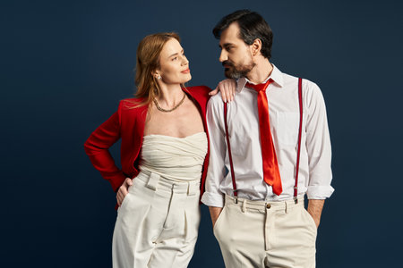 A fashionable middle aged couple displays elegance and charm in a studio with a striking background.の写真素材