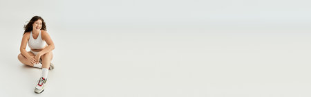 Plus size woman flaunts her beauty in stylish underwear during a relaxed moment.の写真素材