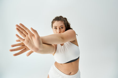 Young plus size woman models fashionable underwear with grace and confidence in a bright space.の写真素材