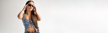 A young woman with short stature confidently models stylish denim clothes in a studio.の写真素材