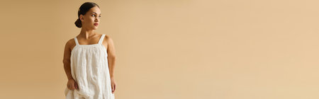 Young woman with short stature poses gracefully in a stylish dress, emphasizing diversity.の写真素材