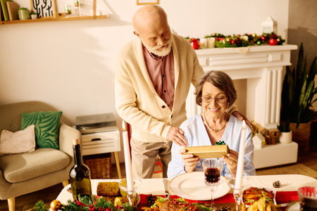 A loving senior couple enjoys a festive Christmas moment at home, opening gifts and smiling.の写真素材