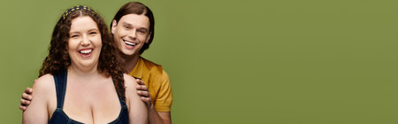 A young plus size woman shares laughter with her male friend, showcasing their bond and joy.の写真素材