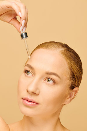 A beautiful plus size woman applies a serum to her face, showcasing her skincare routine.の写真素材