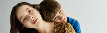 Casual attire highlights the joyful bond between a mother and her son in a serene studio atmosphere.の写真素材