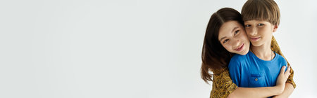 A young mother smiles as she embraces her son in a stylish studio, showcasing their bond.の写真素材