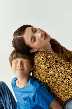 A young mother leans back, eyes closed, enjoying a peaceful moment with her smiling son.の写真素材
