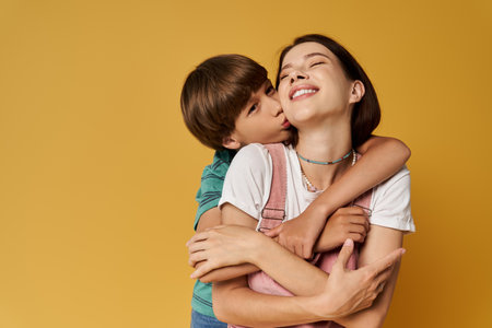 Mother and son share a playful embrace in a warm, modern studio setting filled with joy.の写真素材