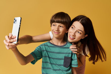 A young mother and her son share a happy moment, capturing their bond in a cheerful studio setting.の写真素材