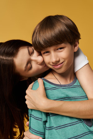 A mother embraces her son with love and joy in a bright studio space, showcasing their bond.の写真素材