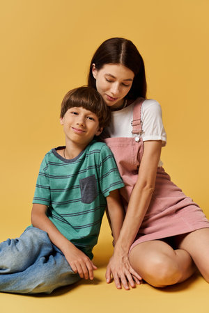 A young mother lovingly sits next to her smiling son in a warm and inviting studio space.の写真素材