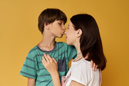 A young mother shares a sweet moment with her son, both in casual outfits and bright colors.の写真素材