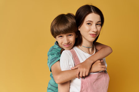 A young mother embraces her son, showcasing a playful bond in a colorful studio.の写真素材