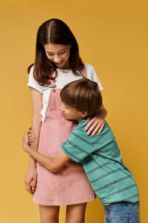 A young mother enjoys a playful embrace with her son in a modern studio backdrop.の写真素材