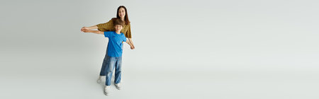 A young mother playfully holds hands of son while they enjoy their time together.の写真素材