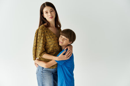 A young mother and her son share a warm hug in a chic studio space, radiating love and connection.の写真素材