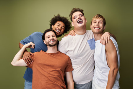 Four friends embrace each other, showcasing their unique styles and joy in a lively atmosphere.の写真素材