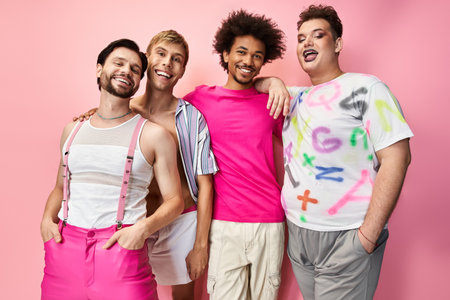 Four friends in bright outfits express joy and pride against a pink backdrop.の写真素材