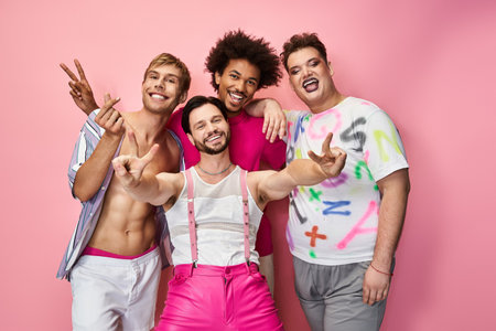 A joyful group of queer friends poses playfully against a bright pink backdrop.の写真素材