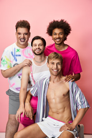 Four joyful people express pride and camaraderie in a bright, colorful studio setting.の写真素材