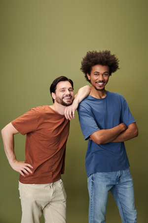 Two friends stand together, smiling and enjoying a lively moment in their cozy setting.の写真素材