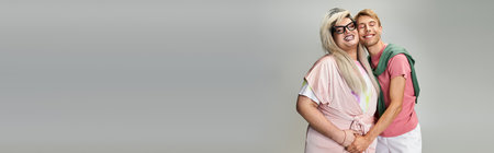 Two friends joyfully embrace, celebrating vibrant LGBTQ expression at a cheerful gathering.の写真素材