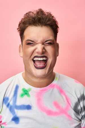 Individual joyfully smiles while showcasing vibrant makeup and colorful attire.の写真素材