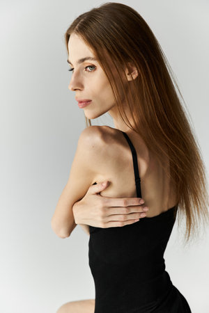 A young woman with anorexia contemplates her reflection, conveying emotion and strength.の写真素材