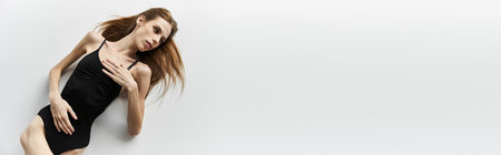 A young woman in a black outfit expresses her battle with anorexia, showcasing her beauty.の写真素材