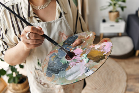 young woman passionately paints in her stylish apartment during the day.の写真素材