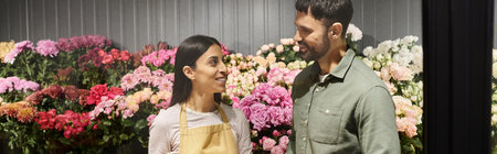 Blooming flowers surround a friendly florist helping a client select the perfect bouquet.の写真素材