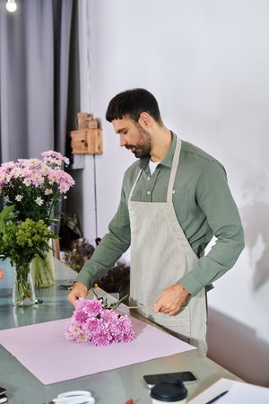 A skilled florist carefully arranges vibrant blooms in his cozy shop, showcasing his expertise.の写真素材