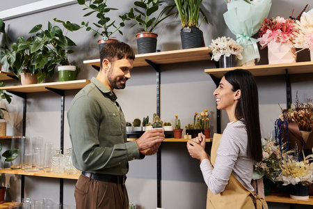 A florist engages with a male client, sharing expertise on beautiful plants and flowers.の写真素材