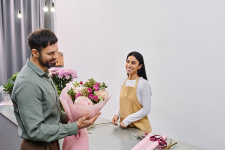 A talented florist engages with a male client while showcasing a stunning bouquet of flowers.の写真素材