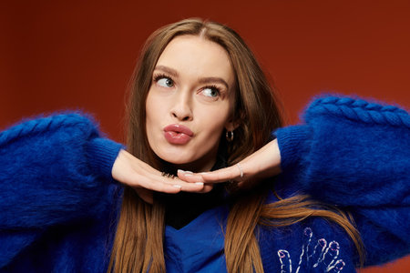 A confident woman with long hair poses playfully against a bright backdrop.の写真素材