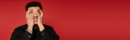 Handsome young man displays a range of emotions while posing against a red backdrop.
