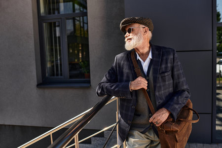 A dapper senior man in a checkered blazer enjoys the crisp autumn air near a contemporary structure.