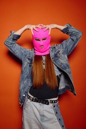 A young man with long red hair expresses strong emotions against a bright background.の写真素材