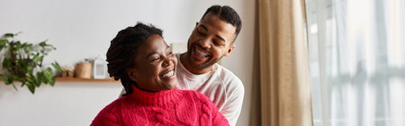 A couple shares laughter and warmth together, enjoying cozy moments in their living room.の写真素材