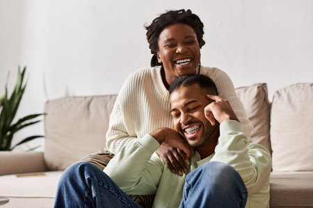 A couple enjoys quality time together, laughing and embracing while cozy indoors during winter.の写真素材