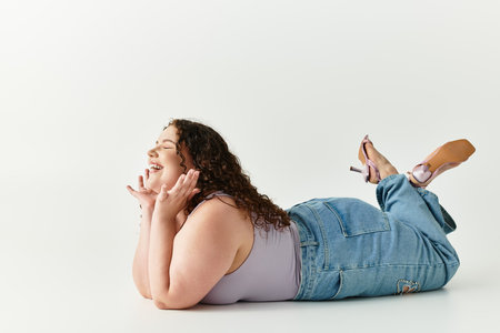 Stylish young woman lies comfortably, radiating joy with a playful expression on her face.の写真素材