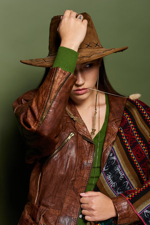 A young woman with flowing brunette hair presents an artistic blend of fashion and culture.の写真素材