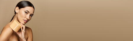 Young woman gently applying skincare, showcasing her radiant skin and natural beauty.の写真素材