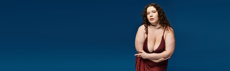 Confident young woman in a stylish dress poses elegantly, expressing fashion sense and beauty.の写真素材